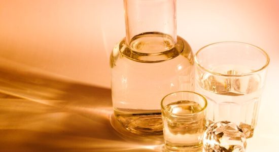 beaker-two-water-glasses-with-shadow-colored-background_23-2147948893