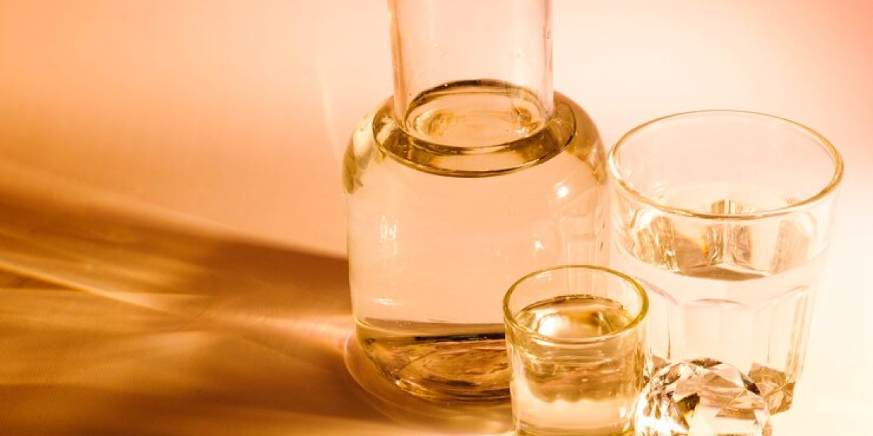 beaker-two-water-glasses-with-shadow-colored-background_23-2147948893